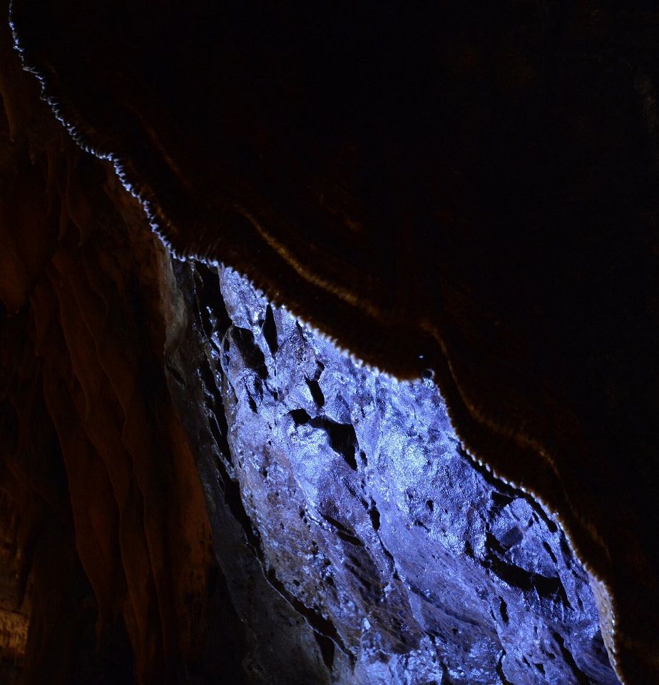 a cave stalactite running diagonally with a purple hue